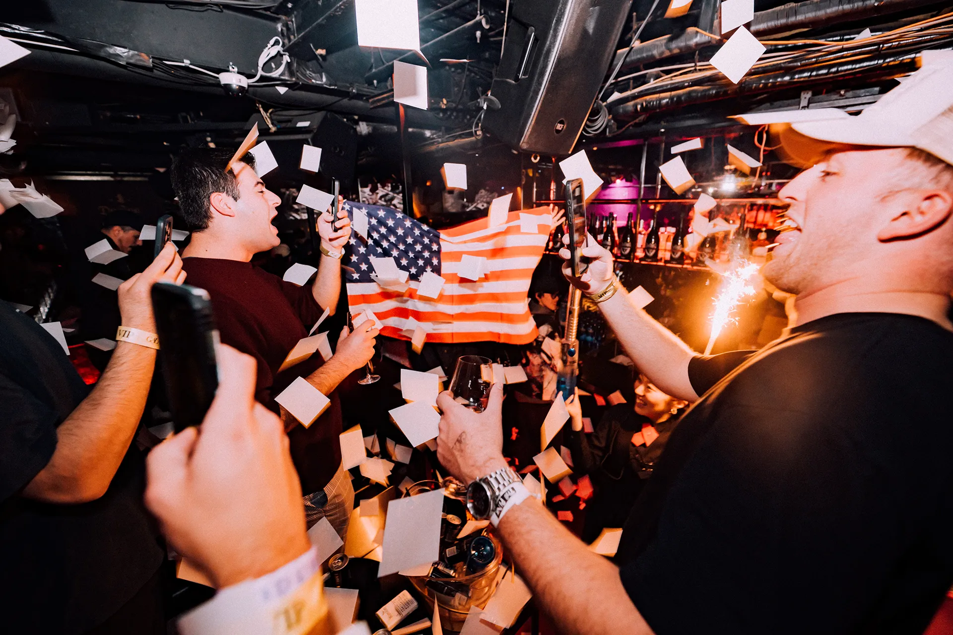 Guests celebrating with sparklers and an American flag at a VIP table at GALA RESORT